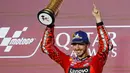 Pembalap Ducati Lenovo Team, Francesco Bagnaia saat merayakan gelar juara di podium MotoGP Qatar di Sirkuit Internasional Lusail, Doha pada 10 Maret 2024. (KARIM JAAFAR/AFP)