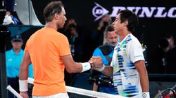 Petenis Spanyol Rafael Nadal (kiri) memberi selamat kepada petenis Amerika Serikat Mackenzie McDonald setelah pertandingan putaran kedua kejuaraan tenis Australian Open di Melbourne, Australia, Rabu (18/1/2023). Rafael Nadal harus tersingkir dari Australian Open 2023 setelah ia mengalami cedera dan kemudian takluk 4-6, 4-6, 5-7 dari petenis Amerika Serikat MacKenzie McDonald. (AP Photo/Dita Alangkara)
