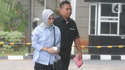 Terpidana General Manager Commercial PT Humpuss Transportasi Kimia, Asty Winasti dikawal petugas berjalan masuk akan menjalani pemeriksaan sebagai saksi di Gedung KPK, Jakarta, Selasa (12/11/2019). (merdeka.com/Dwi Narwoko)