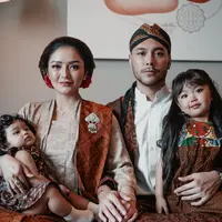 Siti Badriah dan Krisjiana Baharuddin mengajak kedua anaknya menghadiri sebuah acara pernikahan. Keluarga ini pun tampil dengan dress code Jawa sesuai dengan tema acara pernikahan. [@sitibadriahh]
