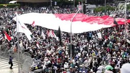 Peserta aksi massa Gerakan Nasional Kedaulatan Rakyat mengibarkan bendera Merah Putih raksasa saat melakukan unjuk rasa di perempatan dekat Gedung Bawaslu, Jakarta, Rabu (22/5/2019). Dalam aksinya, mereka meminta Bawaslu memeriksa kembali hasil Pemilu 2019. (Liputan6.com/Helmi Fithriansyah)