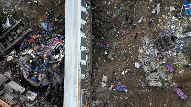 Petugas pemadam kebakaran dan penyelamat beroperasi pada 1 Maret 2023, setelah tabrakan pada Selasa 28 Februari 2023 di Tempe dekat Kota Larissa, Yunani. (Vaggelis Kousioras/AP)