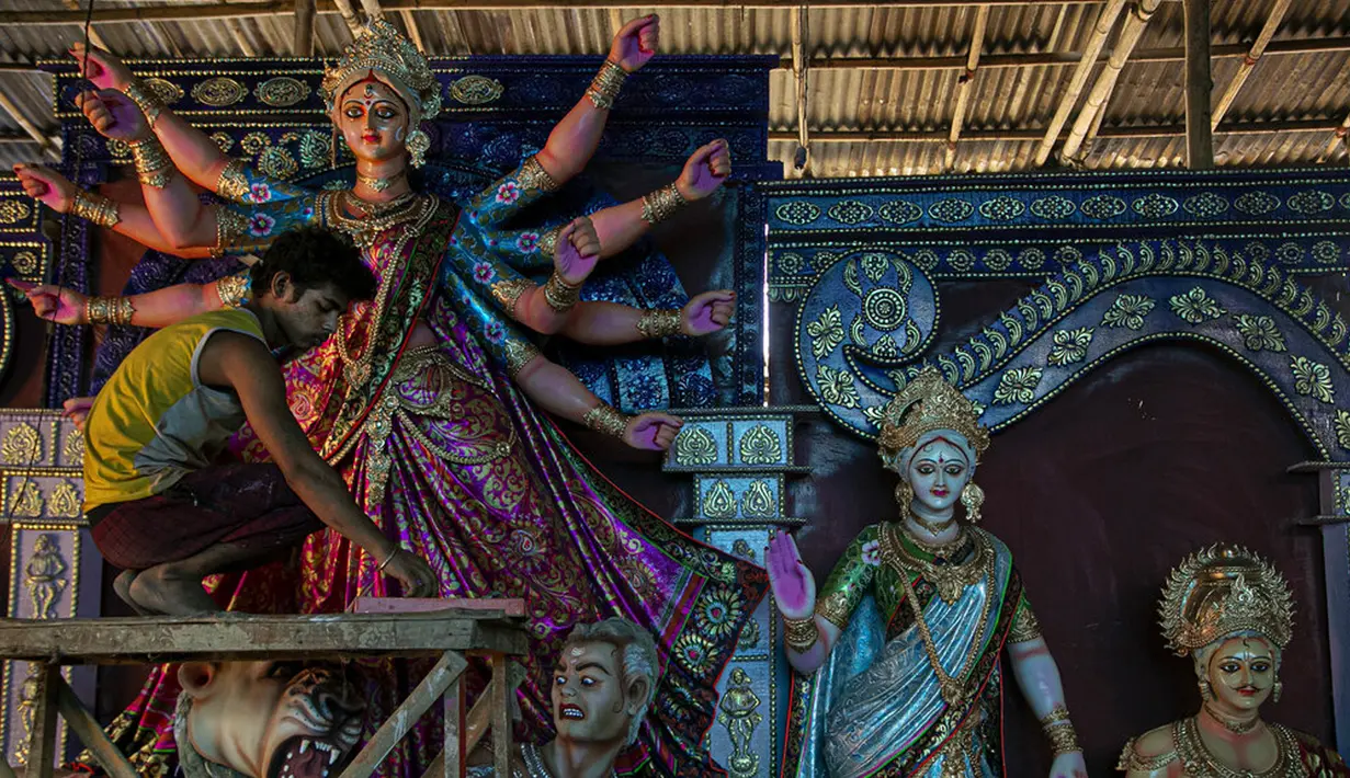 Seniman membuat patung Dewi Durga jelang Festival Durga Puja di Gauhati, India, Jumat (16/10/2020). Para pejabat kesehatan memperingatkan tentang potensi penyebaran COVID-19 selama musim festival keagamaan dengan pertemuan besar di kuil dan distrik perbelanjaan. (AP Photo/Anupam Nath)