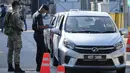 Polisi memeriksa penumpang di kendaraan pada hari pertama Perintah Kontrol Gerakan Penuh (MCO) di Kuala Lumpur, Malaysia (1/6/2021). Penguncian kedua dilakukan untuk mengatasi pandemi yang memburuk yang telah menempatkan sistem perawatan kesehatannya di ambang kehancuran. (AP Photo/Vincent Thian)