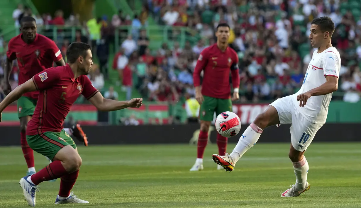 Pemain Portugal Raphael Guerreiro (kiri) berebut bola dengan pemain Republik Ceko Ondrej Lingr pada pertandingan sepak bola UEFA Nations League di Stadion Jose Alvalade, Lisbon, Portugal, 9 Juni 2022. Portugal menang 2-0. (AP Photo/Armando Franca)