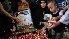 Cucu aktris senior Titi Qadarsih menuangkan air ke pusara sang nenek saat pemakaman di TPU Tanah Kusir, Jakarta, Selasa (23/10). Titi menghembuskan nafas terakhir pada Senin, 22 Oktober 2018. (Liputan6.com/Faizal Fanani)