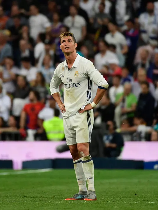Cristiano Ronaldo berdiri dilapangan usai pemain Barcelona mencetak gol ketiga pada La Liga Spanyol di Stadion Santiago Bernabeu, Madrid, (24/4). Bermain sebagai tuan rumah Real Madrid kalah 3-2 atas Barcelona. (AFP Photo/Pierre Philippe Marcou)