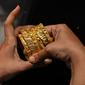 Gambar diambil pada 11 Agustus 2021 menunjukkan seorang pelanggan memegang gelang emas di sebuah toko perhiasan di Mumbai, India. Putus asa mendapatkan uang tunai, banyak keluarga dan usaha kecil menjual perhiasan emas sebagai jaminan untuk mendapatkan pinjaman jangka pendek. (Punit PARANJPE/AFP)