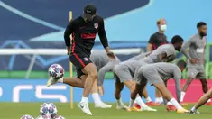 Pelatih Atletico Madrid Diego Simone bermain dengan bola sementara para pemain melakukan peregangan saat sesi latihan di Stadion Jose Alvalade, Lisbon, Portugal, Rabu (12/8/2020). Atletico Madrid akan menghadapi Leipzig pada perempat final Liga Champions. (Miguel A. Lopes/Pool via AP)
