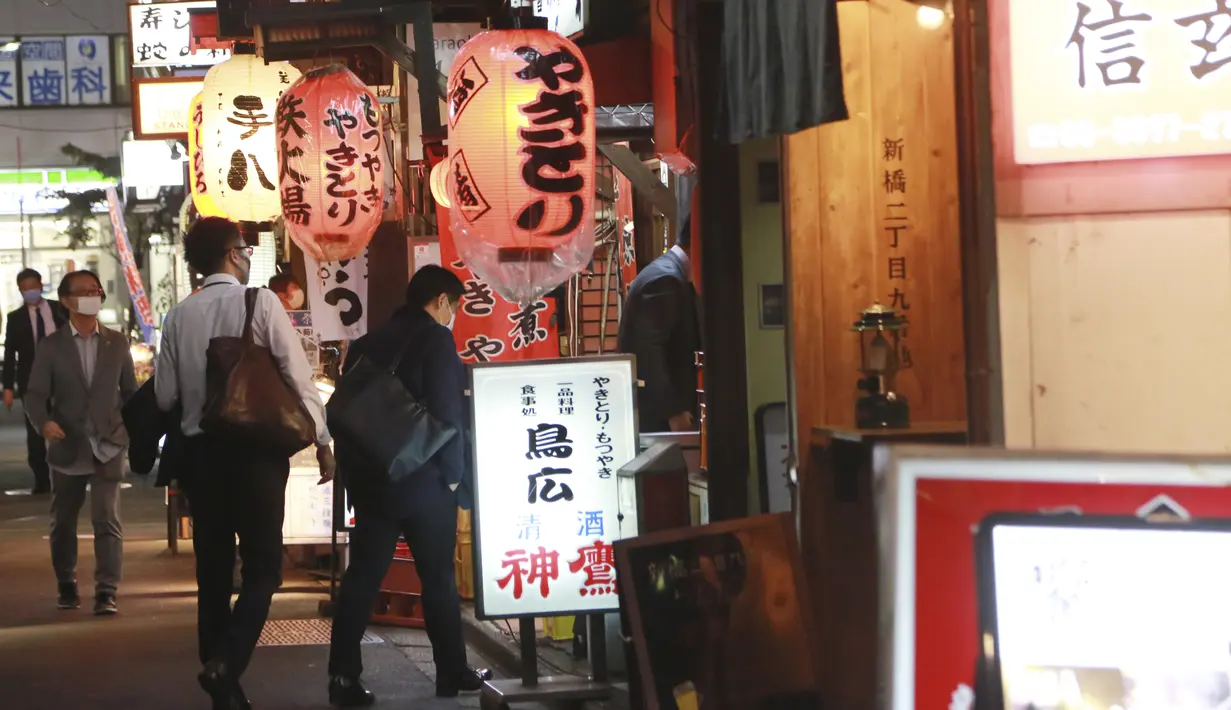 Orang-orang memasuki sebuah restoran di Tokyo, Jepang, Senin (25/10/2021). Pemerintah Metropolitan Tokyo mencabut seluruh pembatasan di tempat-tempat makan menyusul penurunan jumlah kasus corona COVID-19 harian di negara itu. (AP Photo/Koji Sasahara)