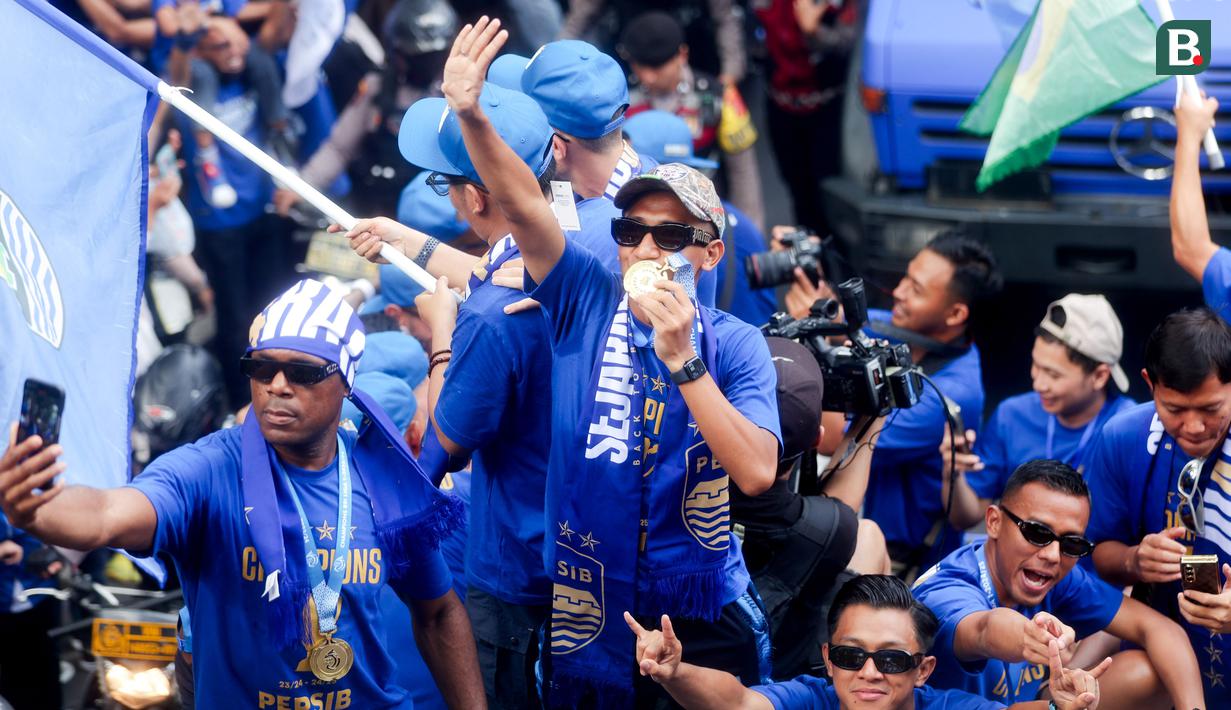 Pemain Persib Bandung, Beckham Putra, menyapa warga saat pawai juara di Bandung, Minggu (25/5/2025). (Bola.com/M Iqbal Ichsan)