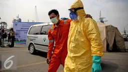 Petugas membopong seorang saat mengikuti simulasi di Tanjung Priok, Jakarta (14/4). Penanggulangan PHEIC bertujuan untuk meningkatkan pengetahuan dan kemampuan stakeholder dalam mendeteksi dan merespon apabila terjadi PHEIC. (Liputan6.com/Faizal Fanani)