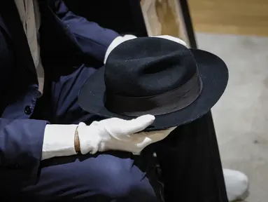 Topi Fedora milik penyanyi AS Michael Jackson, terbuat dari wol dan dilapisi sutra, dipajang sebelum dilelang di Paris, pada 12 September 2023. Topi tersebut adalah salah satu barang yang akan dilelang di rumah lelang Drouot Paris pada 26 September 2023. (Geoffroy VAN DER HASSELT / AFP)