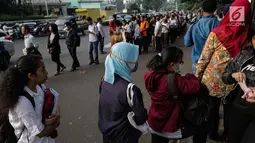 Masyarakat mengantre untuk menaiki bus Transjakarta di depan Cibubur Junction, Jakarta, Senin (16/4). Aturan ganjil genap untuk kendaraan pribadi diujicobakan di Gerbang Tol Cibubur II hari, ini Senin 16 April 2018. (Liputan6.com/Faizal Fanani)