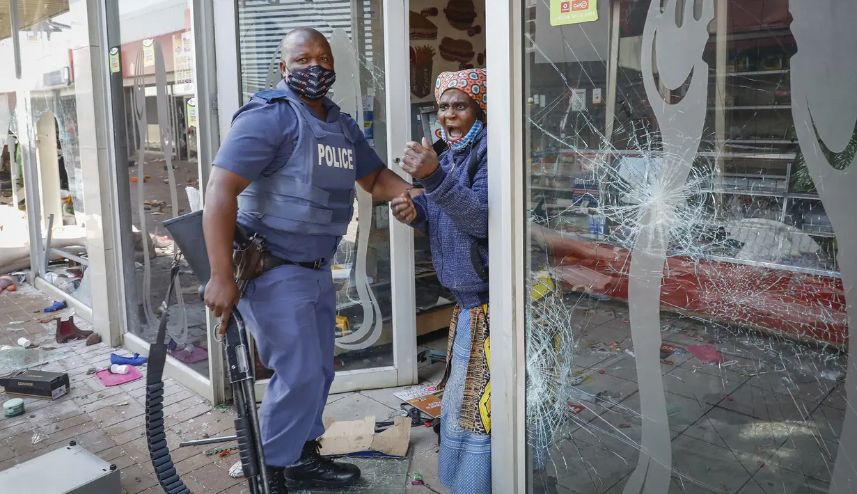 Seorang wanita tua berteriak ketika ditangkap anggota polisi setelah penjarahan dan perusakan di Lotsoho Mall di Katlehong, timur Johannesburg, Senin (12/7/2021). Setelah pemenjaraan mantan Presiden Jacob Zuma, situasi di Afrika Selatan tidak kondusif sejak Minggu, 11 Juli 2021. (Phill Magakoe/AFP)