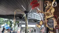 Penumpang Commuter Line atau KRL melintasi patung Ogoh-Ogoh yang dipajang di Stasiun Tebet, Jakarta Selatan, Selasa (1/3/2022). Patung Ogoh-Ogoh tersebut dipajang dalam rangka menyambut Hari Raya Nyepi Tahun Baru Saka 1944 yang jatuh pada 3 Maret mendatang. (merdeka.com/Iqbal S. Nugroho)