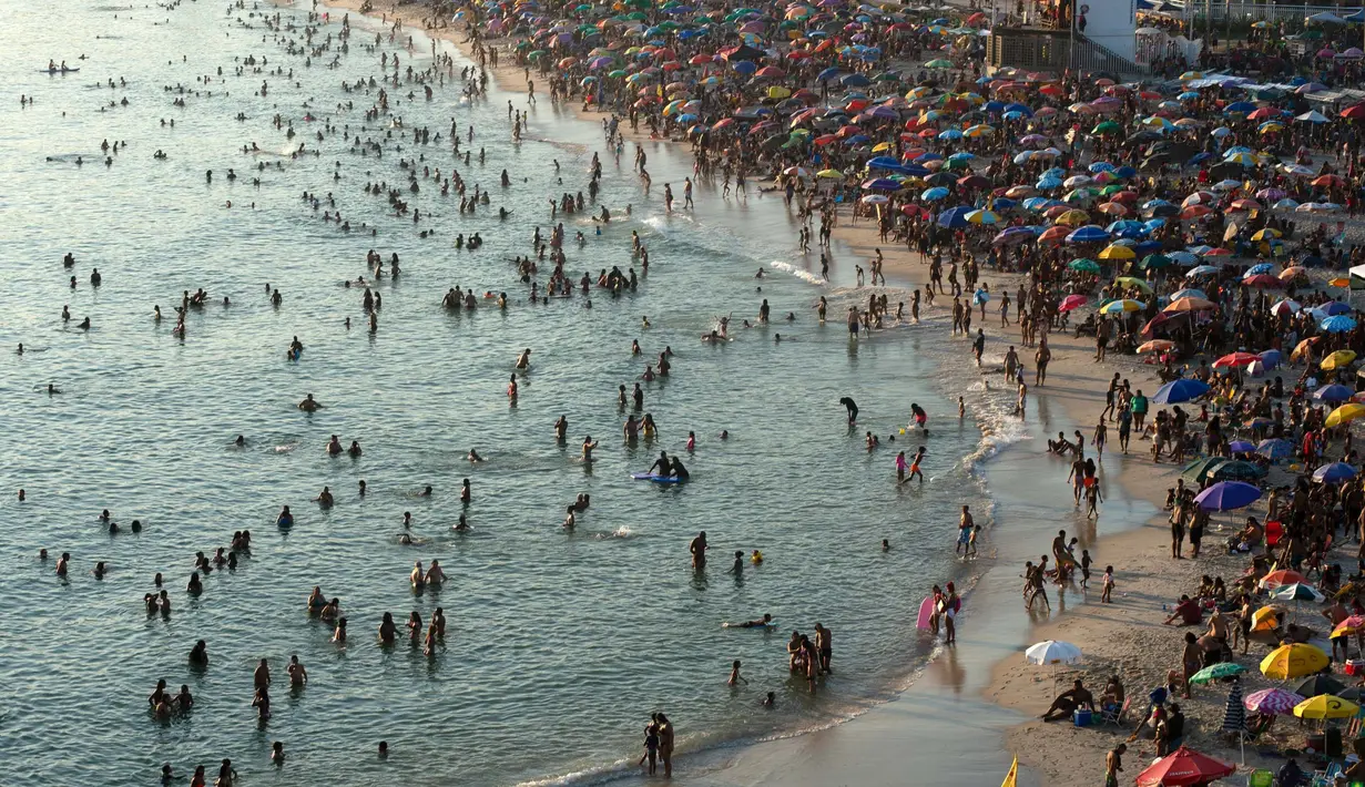 Foto udara menunjukkan orang-orang menikmati pantai Recreio dos Bandeirantes di tengah gelombang panas di Rio de Janeiro, Brasil, pada 17 Maret 2024. (TERCIO TEIXEIRA/AFP)