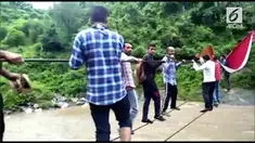 Penduduk desa dan orang-orang yang merayakan festival Hindu di India terpaksa menyeberangi sungai yang banjir dengan tali.