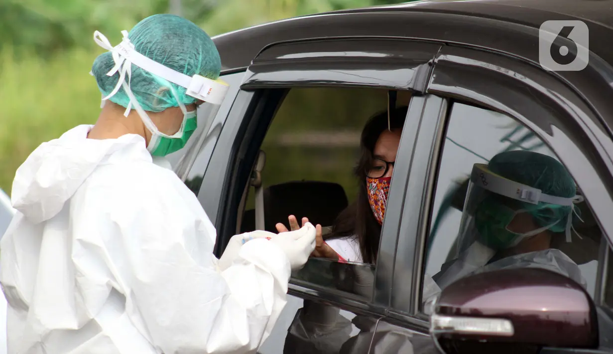 Petugas medis memberi pelayanan tes cepat diagnosa COVID-19 secara drive thru di titik pengecekan Terminal Jatijajar, Depok, Jawa Barat, Kamis (28/5/2020). Tes cepat ini hasilnya akan langsung dikonfirmasi melalui aplikasi dan dilaksanakan hingga Jumat (29/5).  (Liputan6.com/Helmi Fithriansyah)