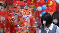 Orang-orang berbelanja di pasar "Tet" Tahun Baru Imlek tradisional di kawasan tua Hanoi, Vietnam, Jumat (28/1/2022). Vietnam merayakan Tahun Baru Imlek yang akan datang di tengah peringatan terhadap perjalanan dan pertemuan besar karena COVID -19. (AP Photo/Hau Dinh)