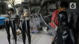 Para pekerja menyelesaikan pembuatan maneken di Kebon Jeruk, Jakarta Barat, Senin (28/12/2020). Pandemi COVID-19 berdampak pada sepinya pesanan pembuatan patung yang biasa dipakai untuk memajang pakaian tersebut. (merdeka.com/Dwi Narwoko)