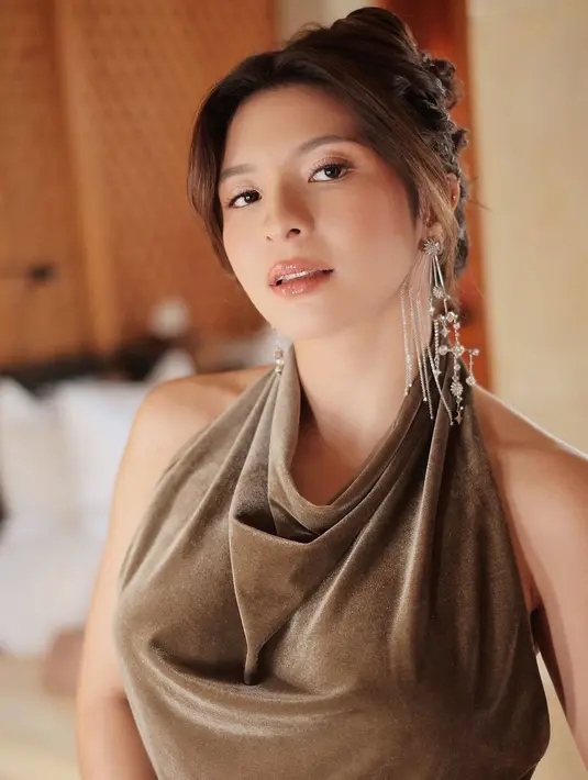 Dipermanis dengan anting menjuntai dan handbag warna silver yang selaras. [@sharazaaa]