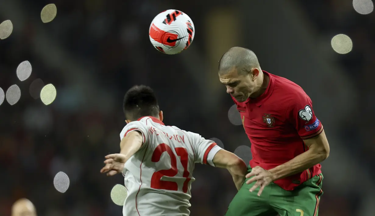 Bek Portugal Pepe melompat untuk merebut bola dari gelandang Makedonia Utara Tihomir Kostadinov pada playoff Kualifikasi Piala Dunia 2022 di Estadio Do Dragao, Rabu (30/3/2022) dinihari WIB. Cristiano Ronaldo dan timnas Portugal lolos usai menang 2-0 atas Makedonia Utara. (AP Photo/Luis Vieira)
