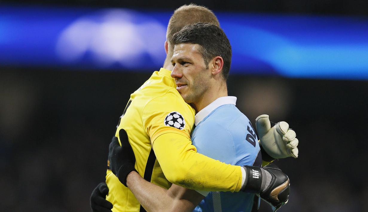 Pemain Manchester City, Martin Demichelis (kanan) dan rekannya Joe Hart berpelukan usai bermain imbang melawan Dynamo Kiev pada leg kedua babak 16 besar Liga Champions di Stadion Etihad, Rabu (16/3/2016) dini hari WIB. (Reuters/Jason Cairnduff).