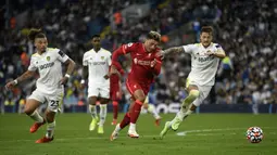 Pemain Liverpool Alex Oxlade-Chamberlain (tengah) berebut bola dengan pemain Leeds United Liam Cooper (kanan) pada pertandingan Liga Inggris di Elland Road, Leeds, Inggris, 12 September 2021. Liverpool menang 3-0. (Oli SCARFF/AFP)