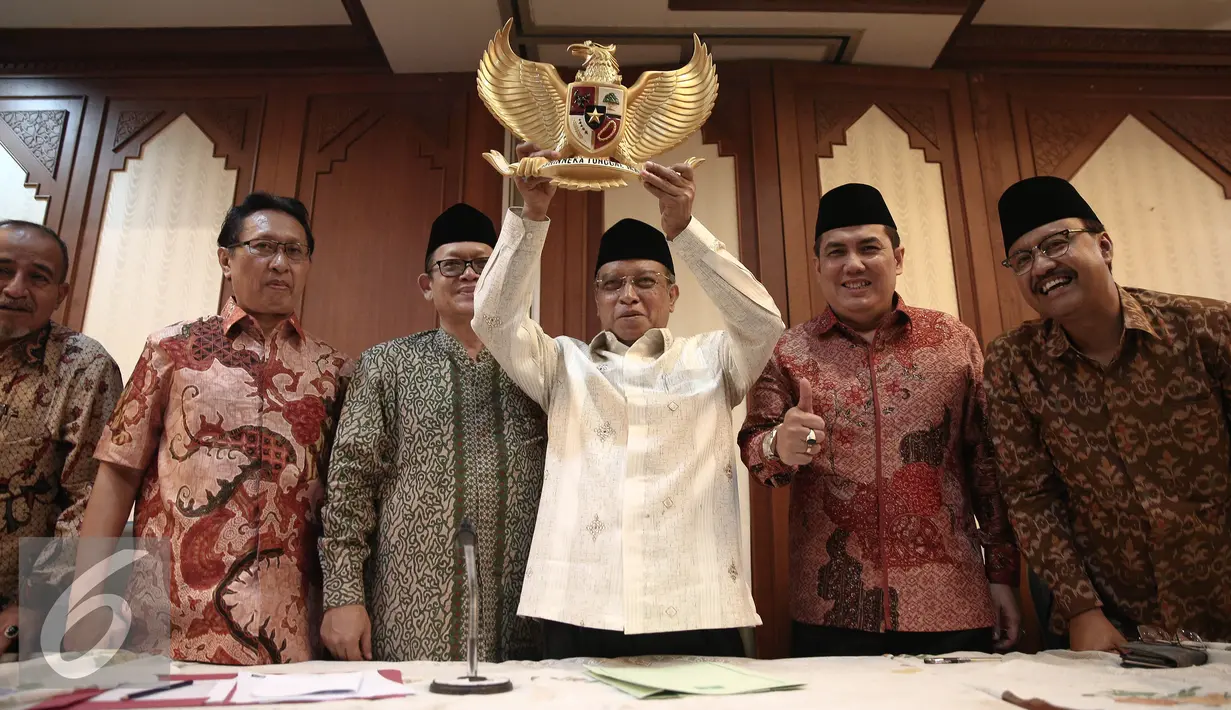 Ketua Umum PBNU KH Said Aqil Siradj mengangkat lambang negara Garuda Pancasila usai menggelar konferensi pers di Gedung PBNU, Jakarta, Senin (30/5). PBNU menyambut positif penetapan 1 Juni sebagai Hari Lahir Pancasila. (Liputan6.com/Faizal Fanani)