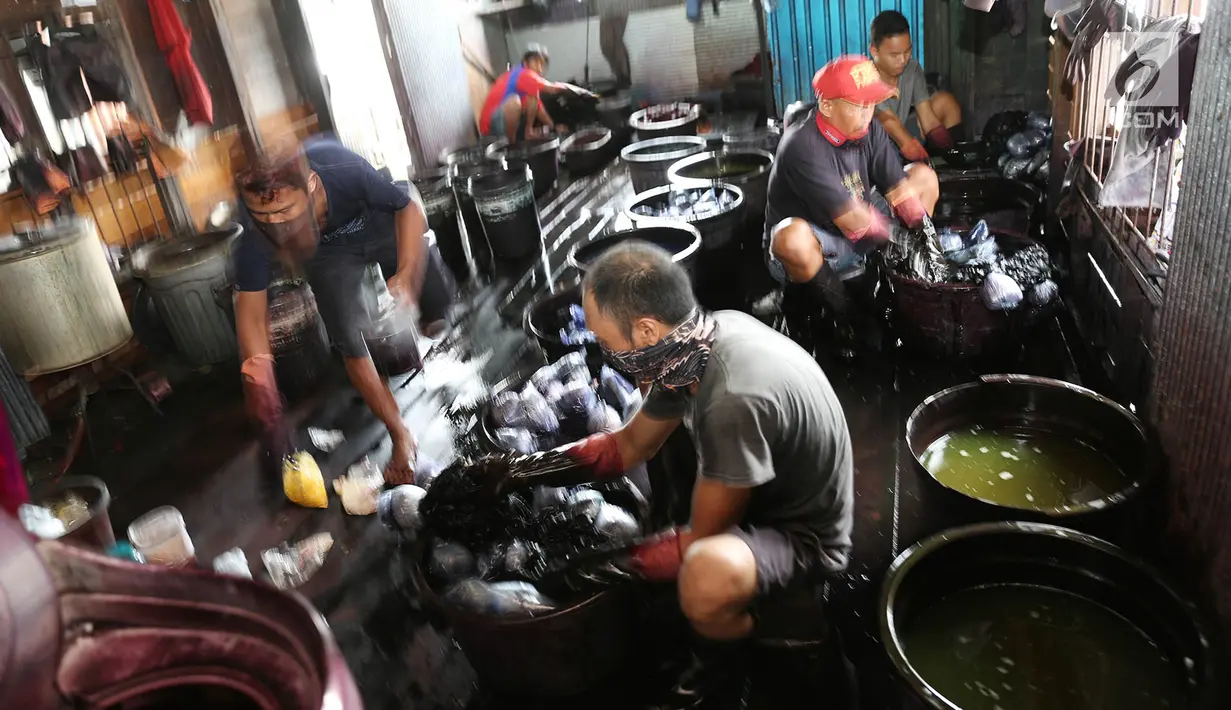 Pekerja mewarnai kain sasirangan di kawasan Banjarmasin, Kalimantan Selatan, Senin (26/3). Proses pewarnaan kain ini dengan menggunakan bahan perintang seperti tali, benang atau sejenisnya menurut corak-corak tertentu. (Liputan6.com/Immanuel Antonius)