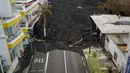 Aliran lahar menghancurkan rumah-rumah saat gunung berapi terus meletus di pulau Canary La Palma, Spanyol, Senin (29/11/2021). Punggung bukit dan mengancam akan memperluas dampak pada tanah yang dievakuasi, infrastruktur dan rumah. (AP/Emilio Morenatti)