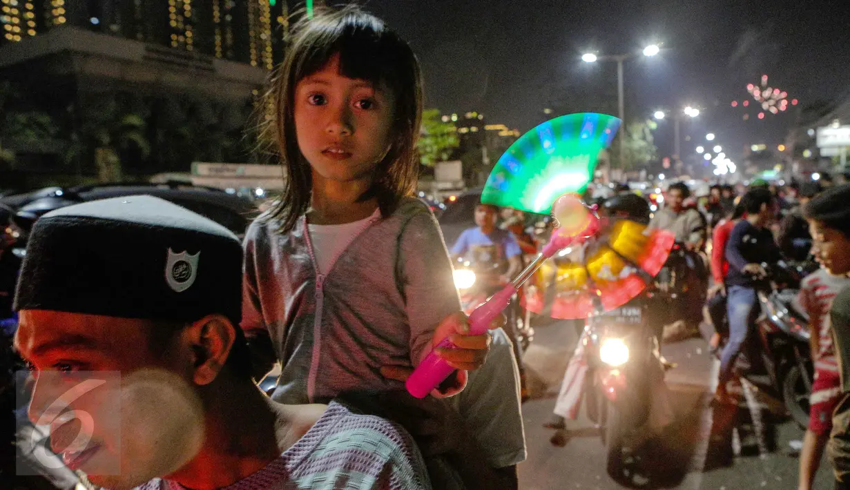 Anak turut mengikuti perayaan malam takbir, bersama Orang Tua nya di Jalan Tanah Abang, Jakarta, Kamis (16/7/2015). Pemerintah melalui Kementerian Agama telah menetapkan 1 Syawal 1436H yang jatuh pada tanggal 17 Juli 2015.(Liputan6.com/Faizal Fanani)