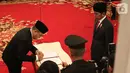 Presiden Joko Widodo atau Jokowi (kanan) menyaksikan komisioner Komisi Kejaksaan RI menandatangani berkas saat upacara pelantikan di Istana Negara, Jakarta, Jumat (1/11/2019). Jokowi melantik sembilan komisioner Komisi Kejaksaan RI periode 2019-2023. (Liputan6.com/Angga Yuniar)