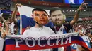 Suporter berpose memakai topeng bintang Portugal, Cristiano Ronaldo dan bintang Argentina, Lionel Messi sebelum laga babak perempat final Piala Dunia 2018 antara Rusia dan Kroasia di Stadion Olimpiade Fisht, Sabtu (7/7). (AFP PHOTO/Kirill KUDRYAVTSEV)