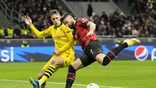 Olivier Giroud dari AC Milan, kanan, berebut bola dengan pemain Dortmund Nico Schlotterbeck pada pertandingan sepak bola grup F Liga Champions antara AC Milan dan Borussia Dortmund di stadion San Siro di Milan, Italia, Selasa, 28 November 2023. (AP Photo /Antonio Calanni)