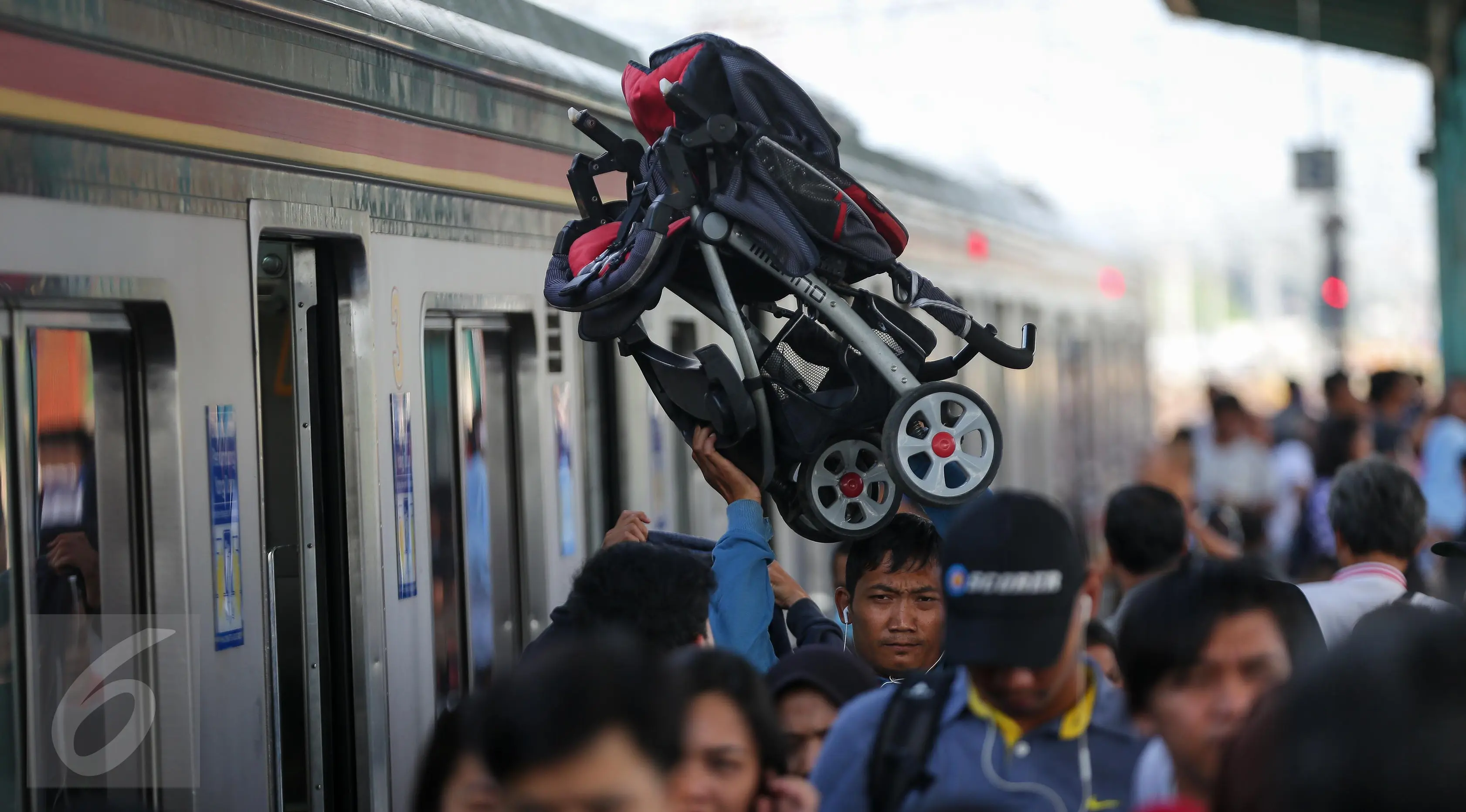 Seorang penumpang membawa kereta bayi setelah turun dari Comuter Line di Stasiun Manggarai, Jakarta, Selasa (28/3). (Liputan6.com/Faizal Fanani)