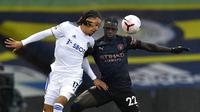 Bek Manchester City, Benjamin Mendy, berebut bola dengan pemain Leeds United, Helder Costa, pada laga Liga Inggris di Stadion Elland Road, Sabtu (3/10/2020). Kedua tim bermain imbang 1-1. (Paul Ellis/Pool via AP)