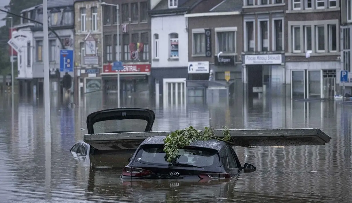 Mobil-mobil terendam banjir setelah Sungai Meuse meluap saat banjir besar di Liege, Belgia, Kamis (15/7/2021). Pihak berwenang di kota Liege, Belgia, mendesak warga untuk mengungsi dari lingkungan di sungai Meuse karena hujan lebat berpotensi membuat banjir makin tinggi. (AP Photo/Valentin Bianchi)