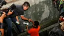 Jatanras Ditreskrimum Polda Metro melakukan identifikasi ditempat pelaku membuang kunci kamar kostan milik Deudeuh Alfi Sahrin alias Tata Chubby,  Jakarta, Jumat (17/4/2015). Kunci ditemukan di selokan dekat stasiun Cawang. (Liputan6.com/Yoppy Renato)