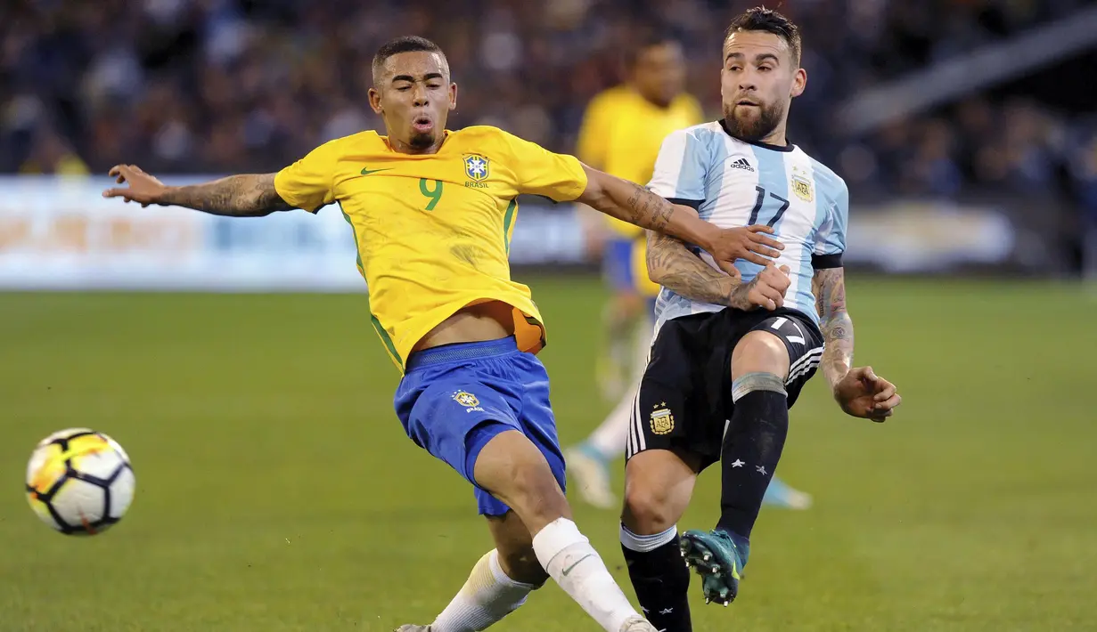 Pemain Argentina, Nicolas Otamendi (kanan) berebut bola dengan pemain Brasil, Gabriel Jesus pada laga persahabatan di Melbourne Cricket Ground, Melbourne, Australia, (9/6/2017). (Joe Castro/AAP Image via AP)