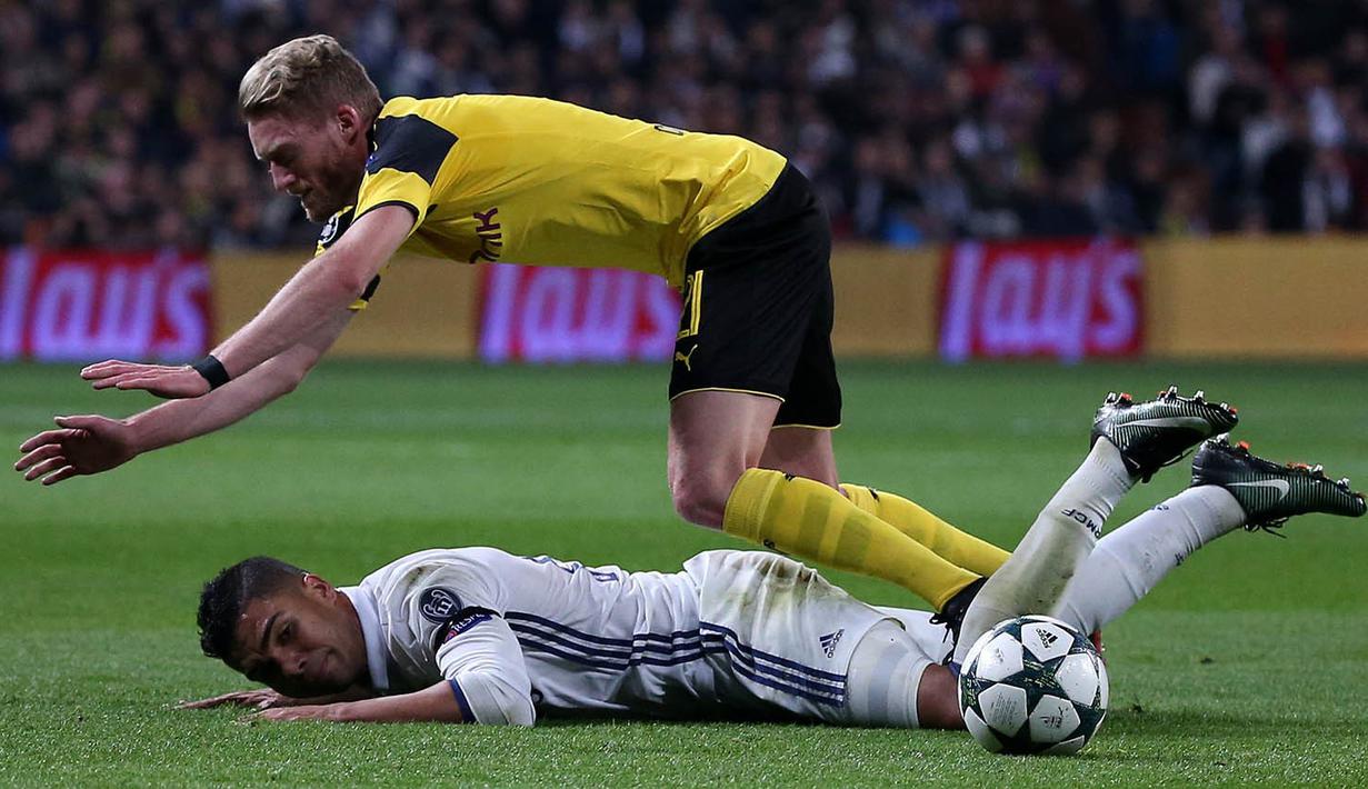 Gelandang Real Madrid, Casemiro, dijatuhkan gelandang Dortmund, Andre Schurrle. Pada peringkat kedua, Real Madrid tertinggal dua poin dari Dortmund. (Reuters/Juan Medina)