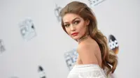 Model cantik Gigi Hadid berpose di atas karpet merah saat tiba menghadiri American Music Awards 2016 di Los Angeles, California, AS, (20/11). Gigi Hadid tampil dengan busana seksi serba putih transparan. (AFP PHOTO/Valerie Macon)