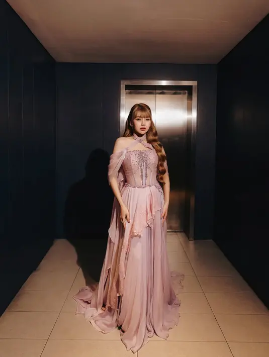 Gaun tersebut hadir dengan detail corset embellished yang mempertegas siluet tubuh, dipadukan kain chiffon menjuntai yang memberi efek melayang bak peri. Sentuhan lace dan beadwork berkilau membuat tampilannya terlihat sangat anggun, apalagi saat terkena lighting panggung.