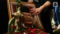 Anggota keluarga dan kerabat memegang foto mantan Menko Bidang Kemaritiman, Rizal Ramli usai proses pemakaman di tempat pemakaman umum (TPU) Jeruk Purut Jakarta, Kamis (4/1/2024). (Liputan6.com/Herman Zakharia)