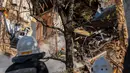 Petugas pemadam kebakaran bekerja setelah sebuah pesawat tak berawak menghantam gedung-gedung di Kyiv, Ukraina, Senin (17/10/2022).  Pesawat tak berawak menghantam sejumlah gedung ibu kota Ukraina pada Senin pagi ledakan tesebut menggema di seluruh Kyiv dan menimbulkan kepanikan sehingga orang-orang berlarian ke lokasi yang aman.  (AP Photo/Roman Hrytsyna)