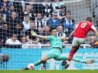 Penjaga gawang Newcastle United, Nick Pope (kiri), berhasil menggagalkan tendangan dari pemain Arsenal, Martin Odegaard, dalam laga pekan ke-35 Premier League 2022/2023 yang berlangsung di St James Park, Minggu (7/5/2023). (AP Photo/Jon Super)