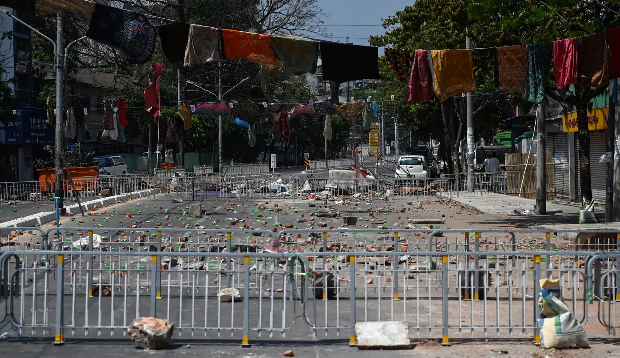 Pakaian tradisional yang banyak dikenakan di Myanmar, longyi, digantung selama demonstrasi menentang kudeta militer di Yangon, Senin (8/3/2021). Jemuran kain tersebut untuk membatasi gerak polisi dan tentara karena berjalan di bawah jemuran pakaian ini dianggap akan membawa sial bagi pria. (STR/AFP)
