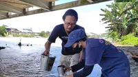 Prigi Arisandi, peneliti dari Ekspedisi Sungai Nusantara (ESN) saat menguji sampel air di sungai Gorontalo (Arfandi/Liputan6.com)